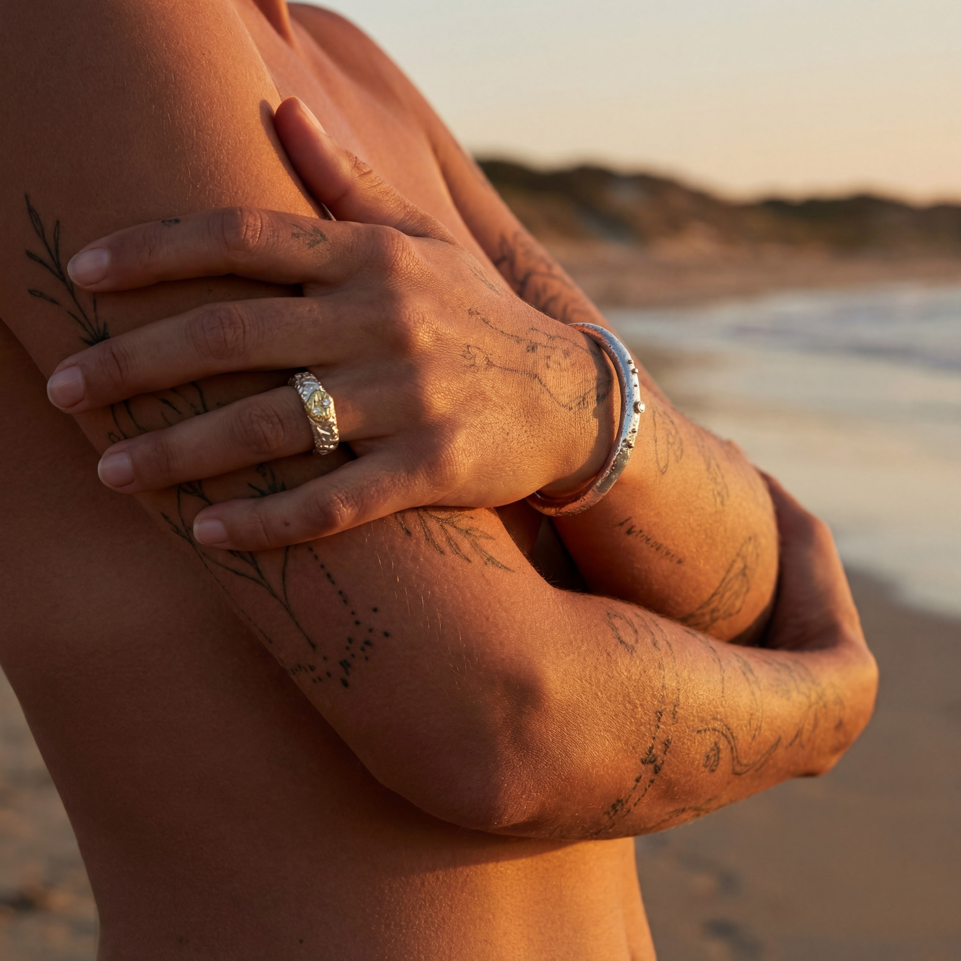 Bracelet jonc Luna Éternelle et bague portés sur la plage au coucher du soleil