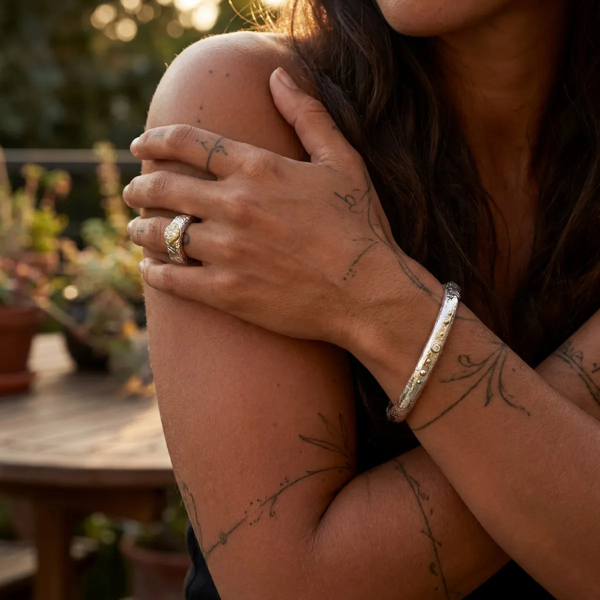 Bracelet jonc Luna Éternelle et bague portés, lumière dorée jardin