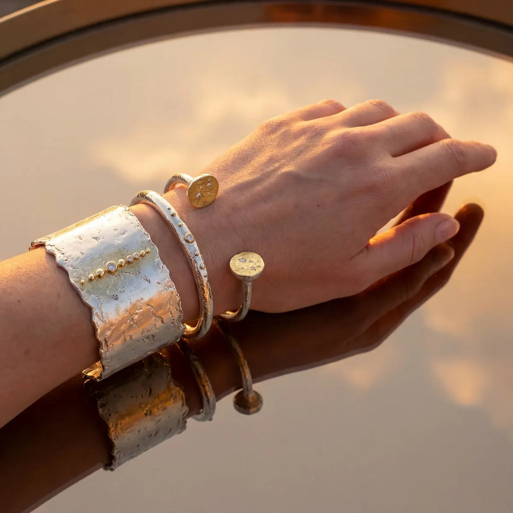 Trio de bracelets Luna en argent et or portés, lumière dorée