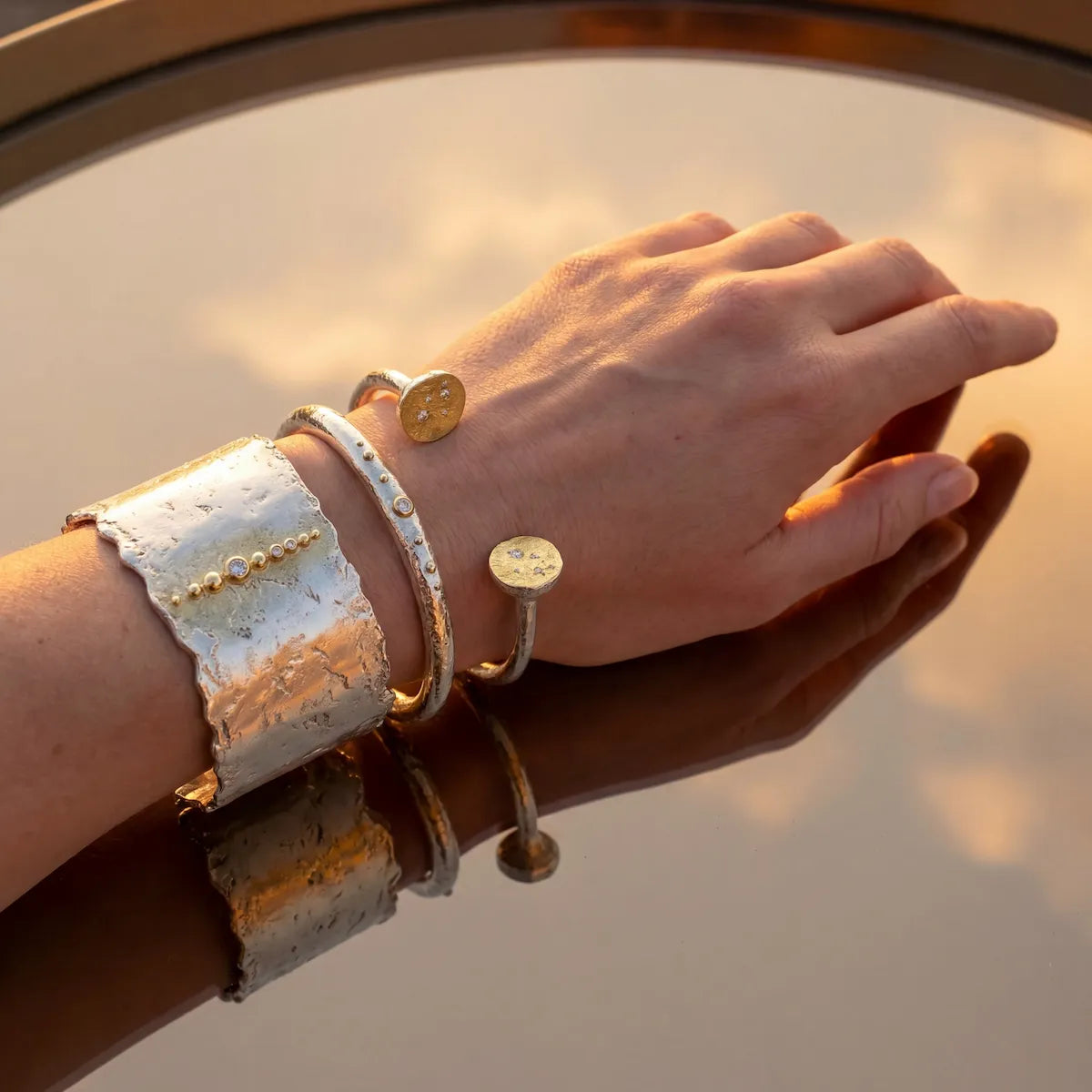 Trio de bracelets Luna en argent et or portés, lumière dorée