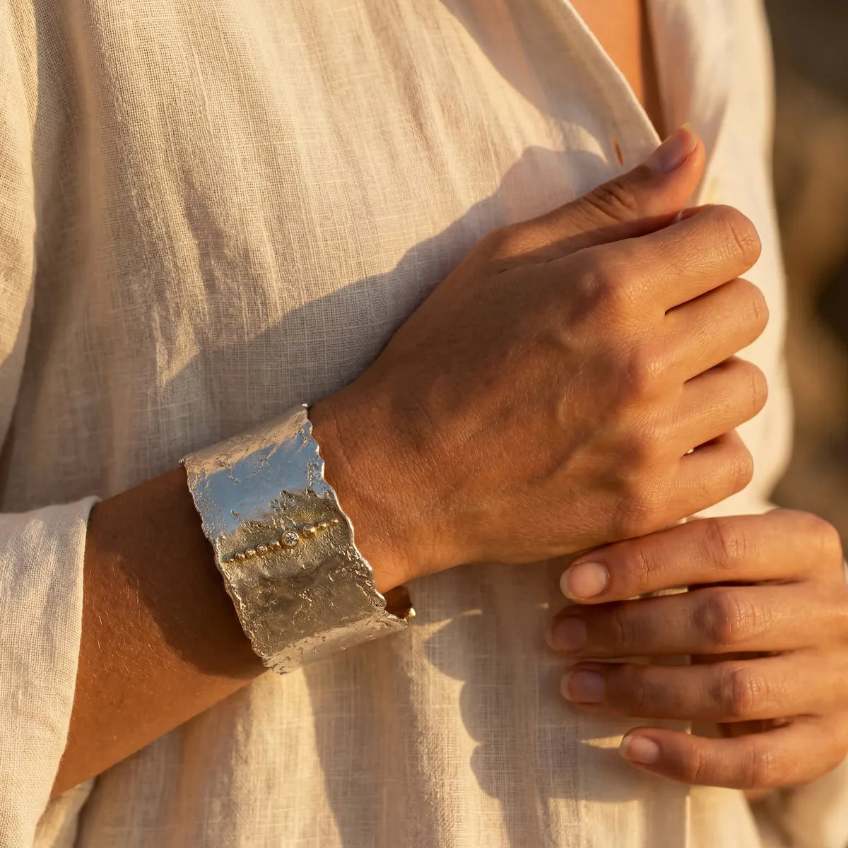 Bracelet manchette Luna Magna en argent porté au poignet, lumière dorée Côte d'Azur